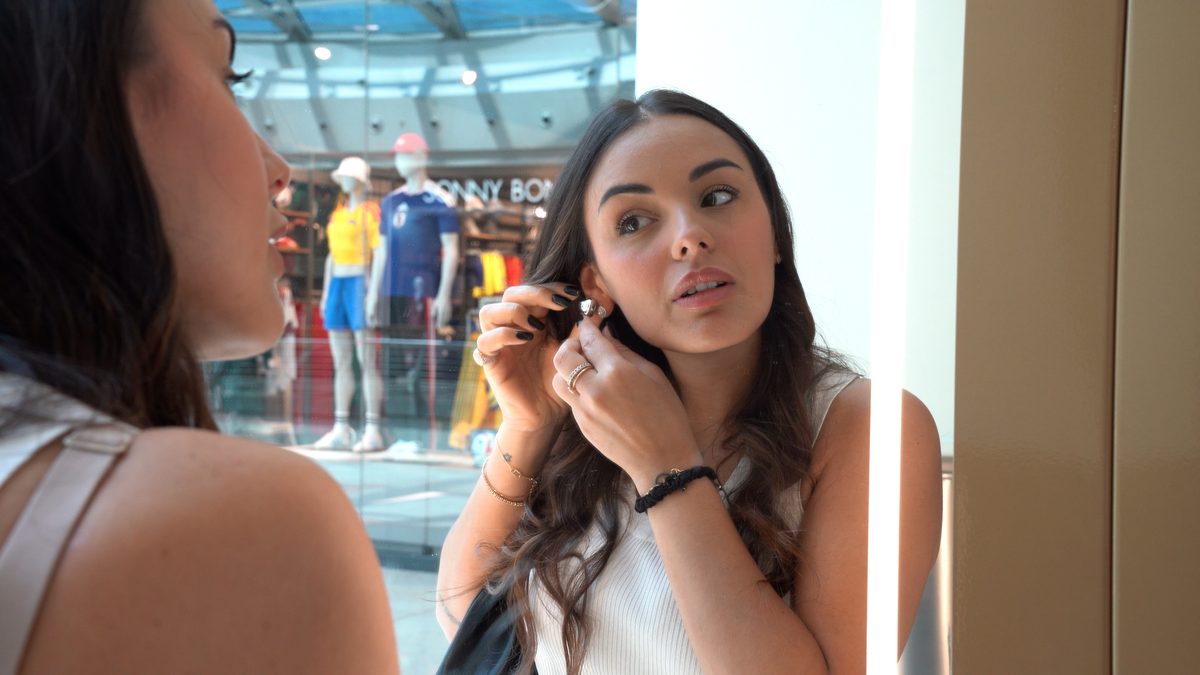 Cliente indossa un orecchino davanti allo specchio del Boutique Pod